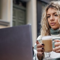 Beautiful Young Woman Working Online From The Outdoor Cafe